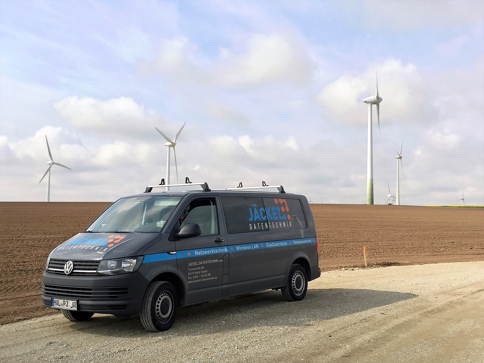 Servicefahrzeug von Jäckel Datentechnik vor Windkraftanlagen